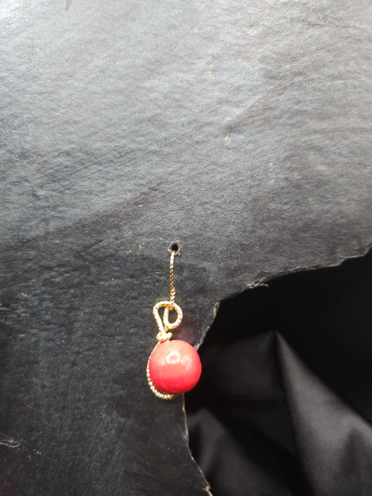 Détail des boucles d'oreilles rouges avec fil plaqué or