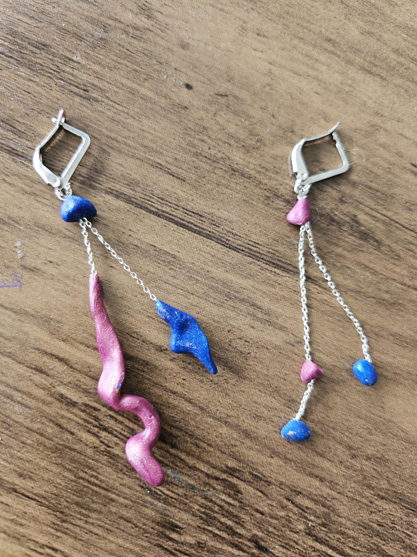 Fine asymmetrical earrings in silver and small pearls.