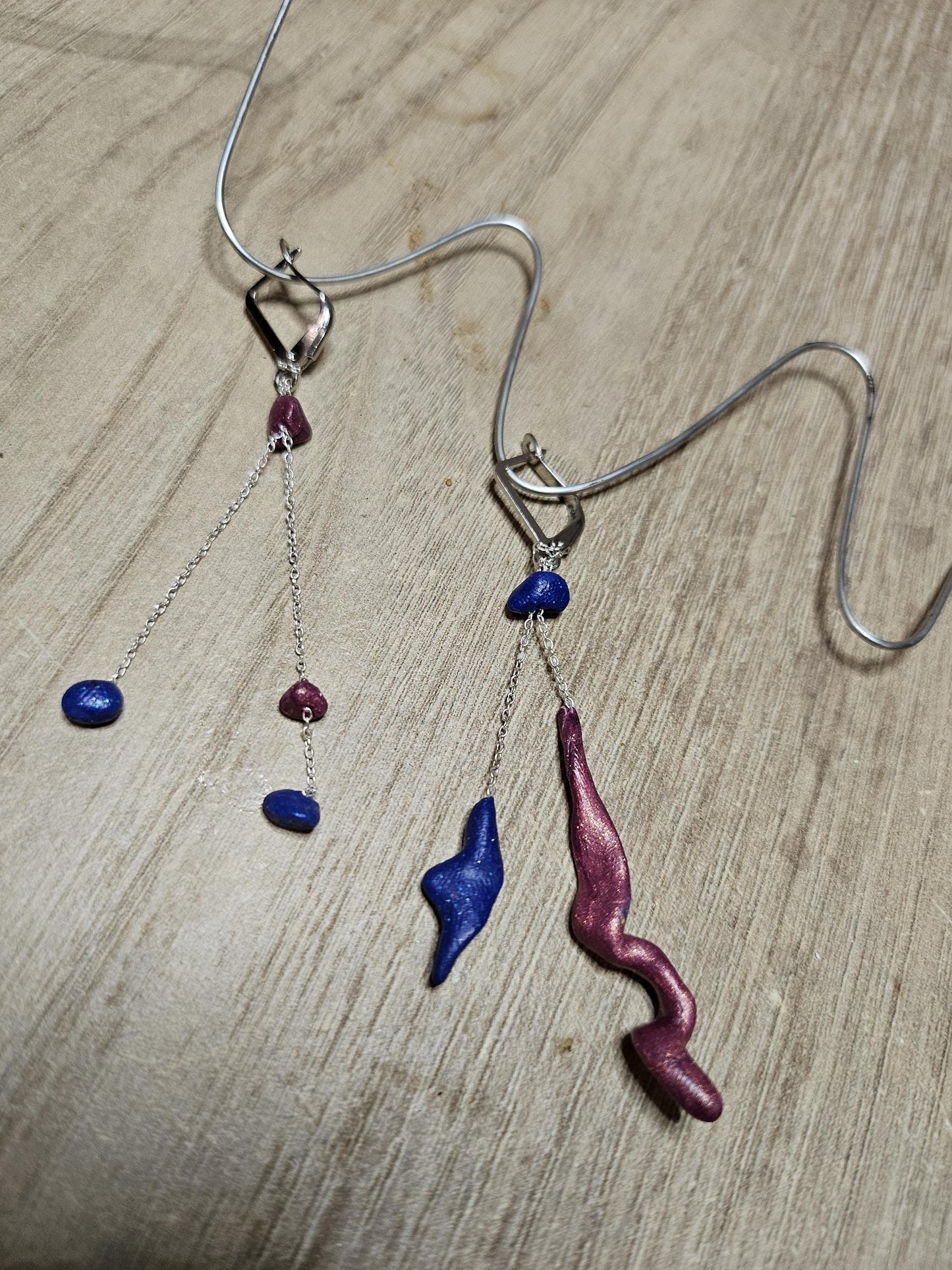 Fine asymmetrical earrings in silver and small pearls.