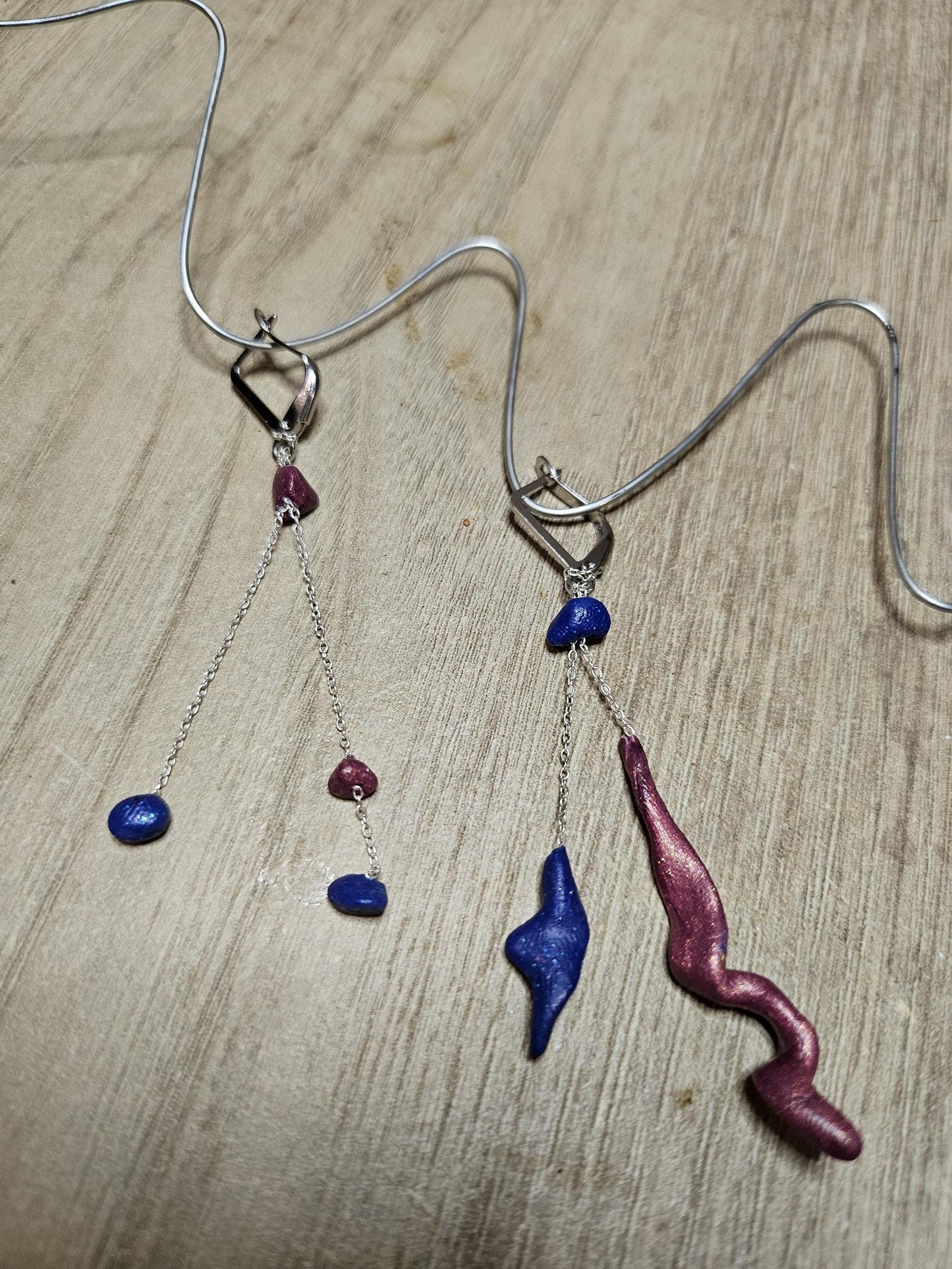 Fine asymmetrical earrings in silver and small pearls.