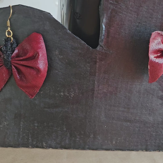 Boucles d'oreilles nœud papillon rouge portées - style élégant bohème