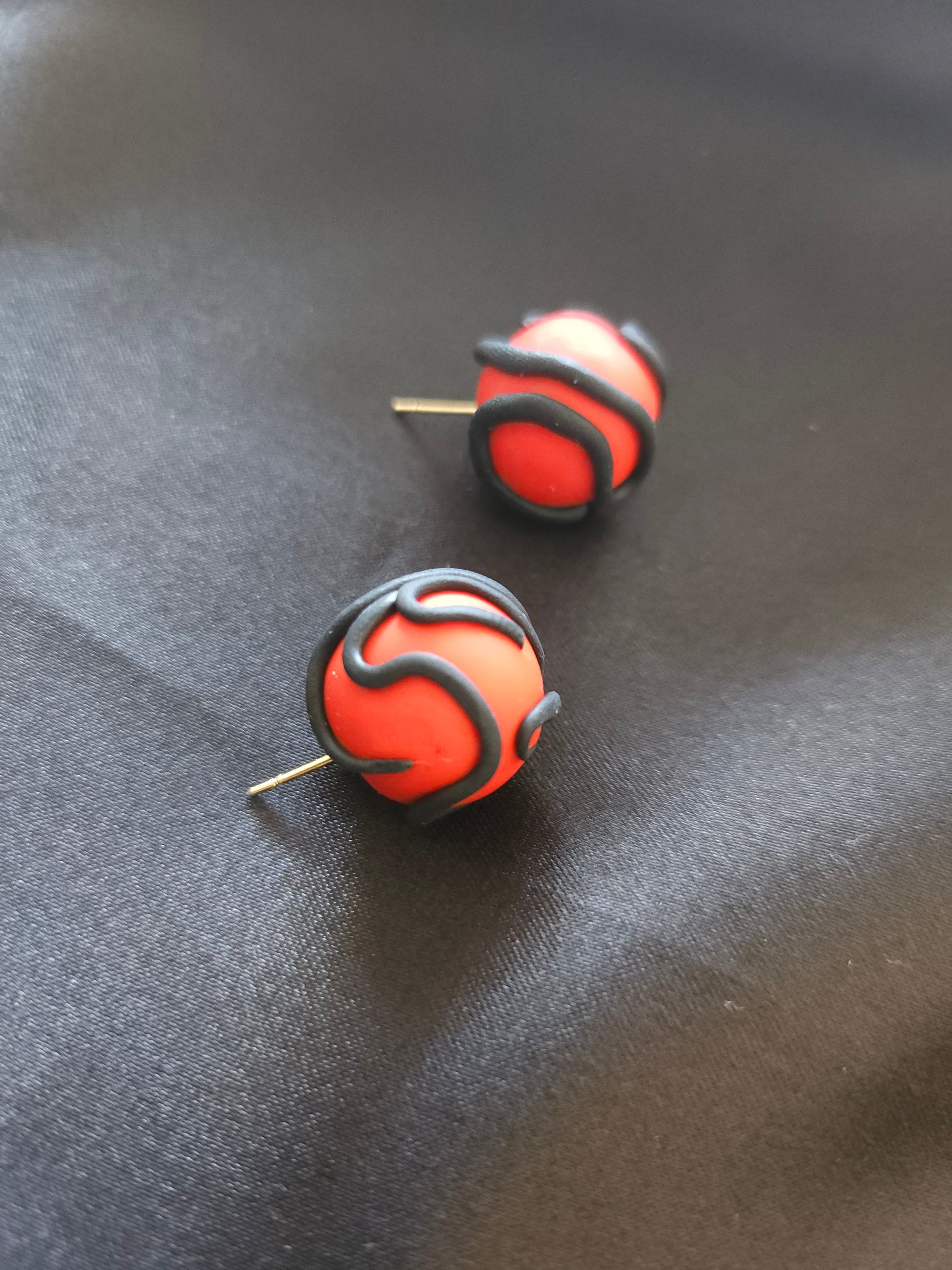 Vue rapprochée des puces d'oreilles rouges à motif serpent noir