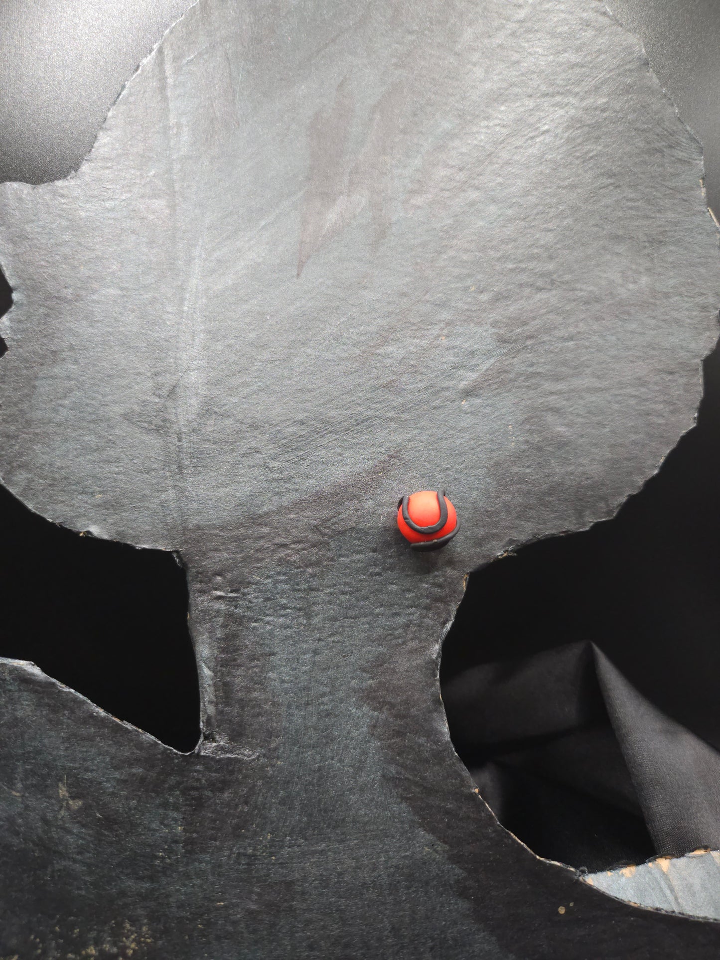 Vue détaillée des puces d'oreilles artisanales rouges serpentées