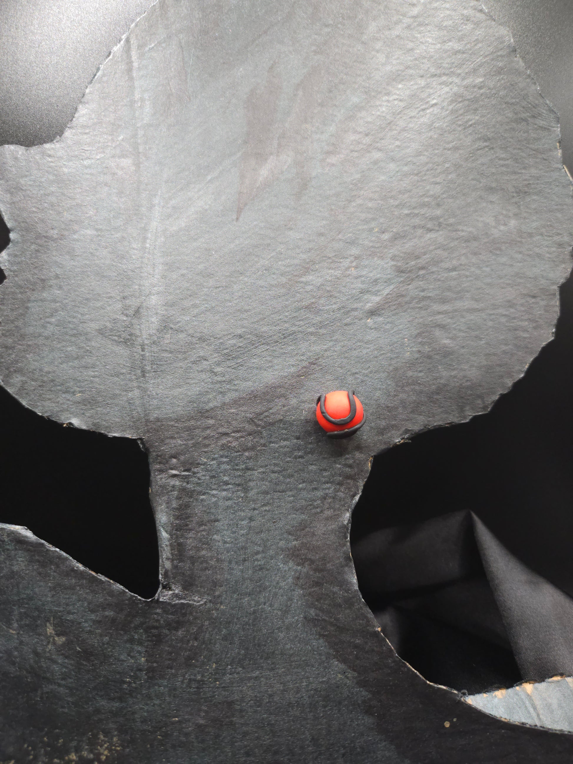 Vue détaillée des puces d'oreilles artisanales rouges serpentées