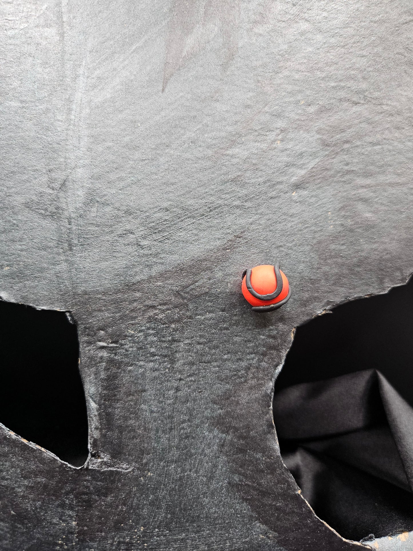 Femme portant des puces d'oreilles rouges avec motif serpent noir