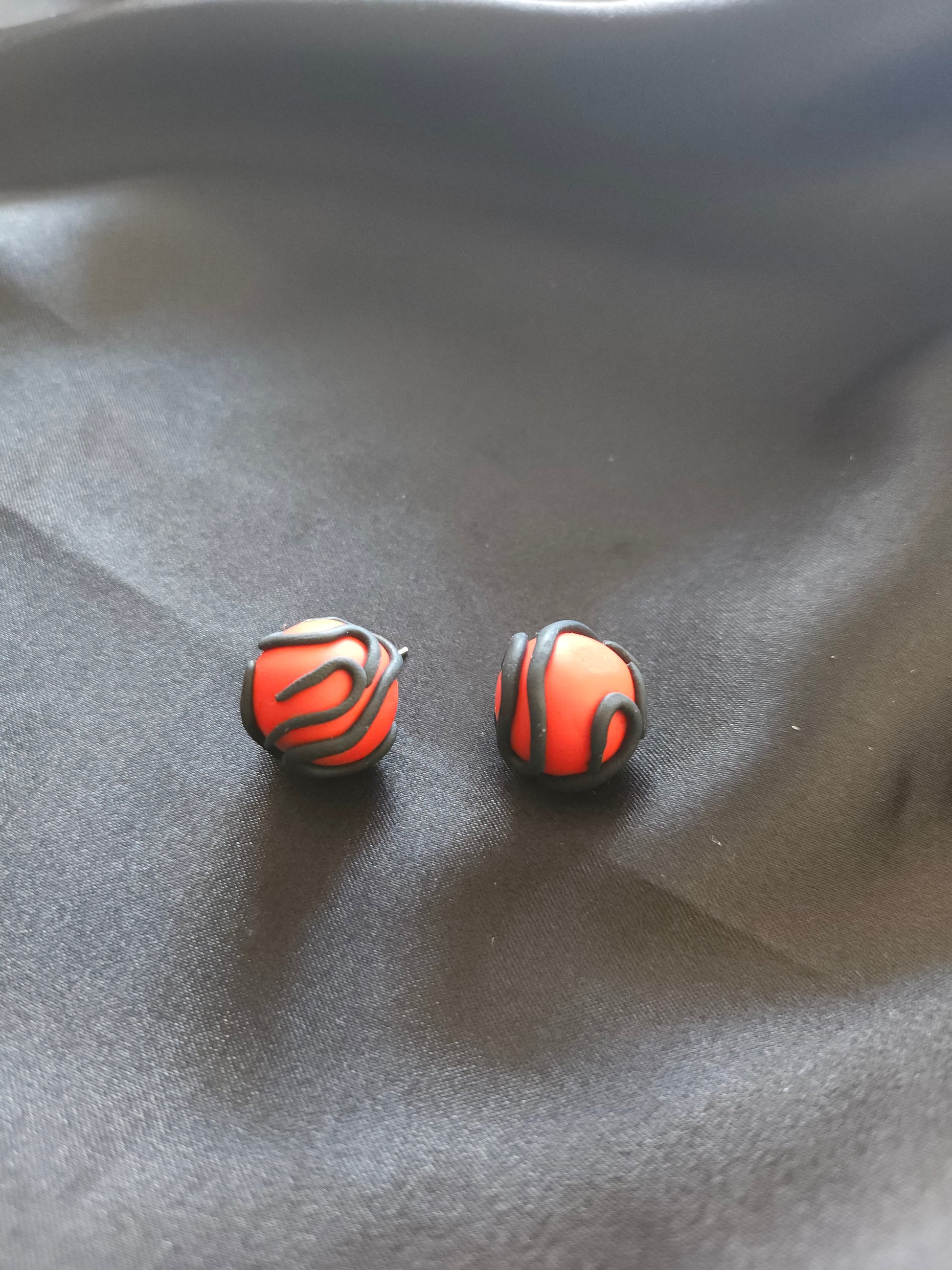 Puces d'oreilles rouges serpentées noires - vue d'ensemble du design artisanal