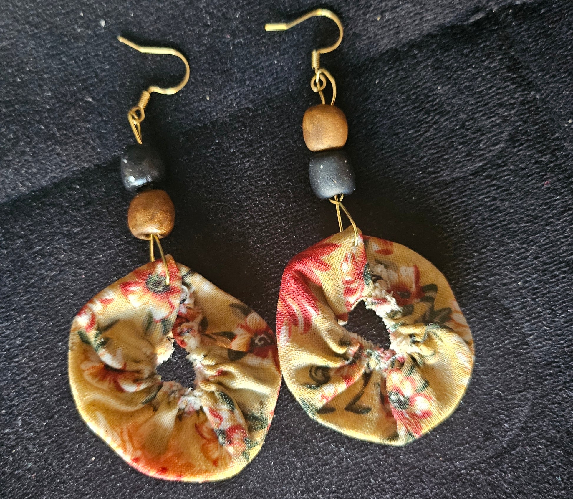 Détail des boucles d'oreilles rondes tissu effet mouillé - finition élégante